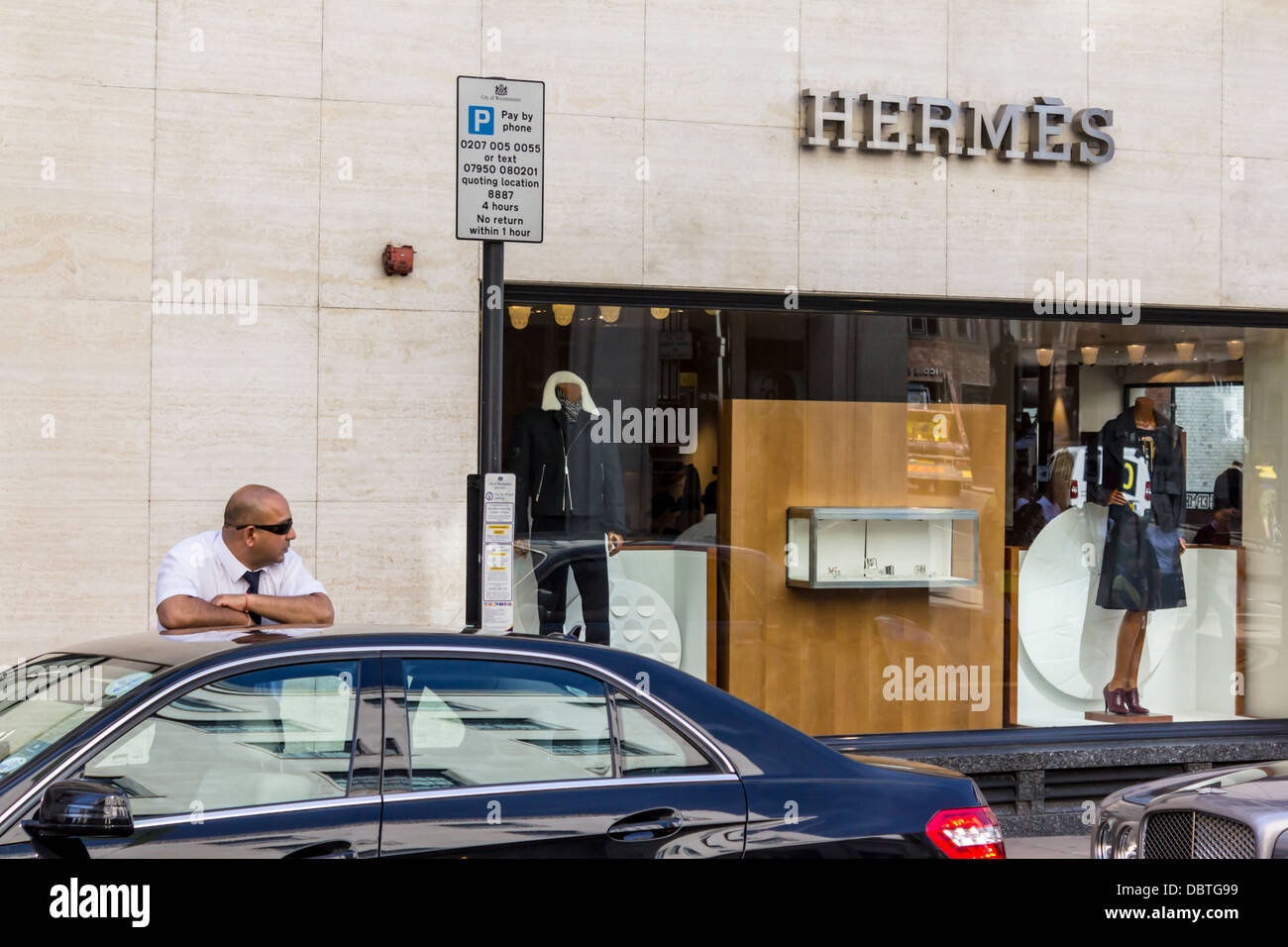 Il driver attende da davanti alla vettura di Hermes su New Bond Street, Londra, Regno Unito Foto Stock