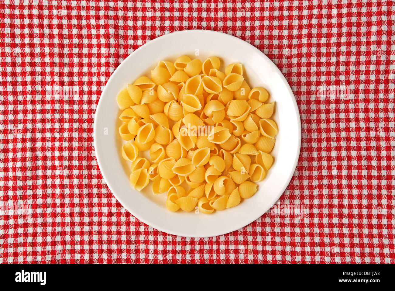 La pasta grezza su piastra bianca sul tavolo da cucina Foto Stock
