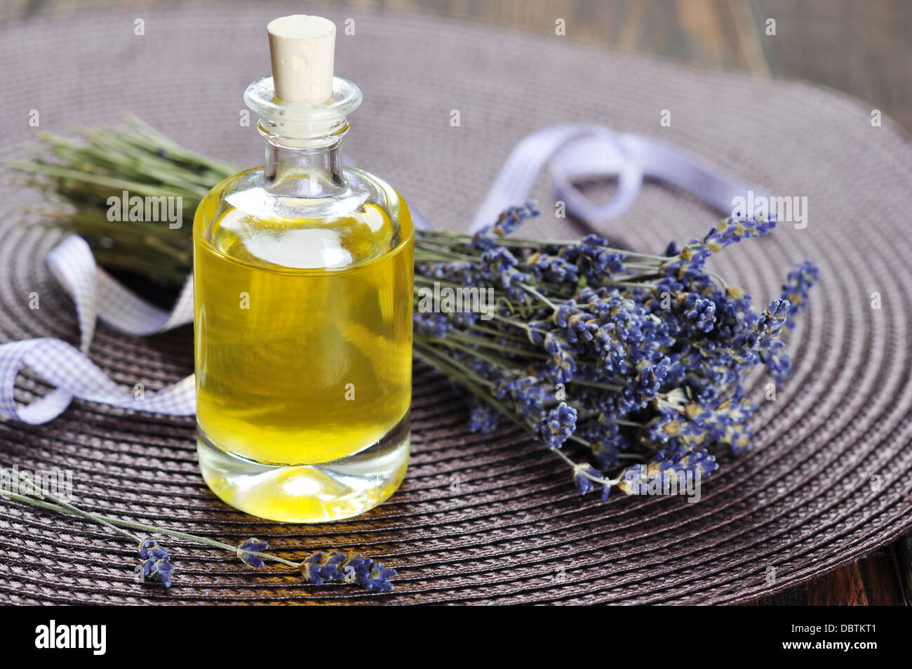 Essenziale di olio di lavanda con fiori freschi in legno Foto Stock
