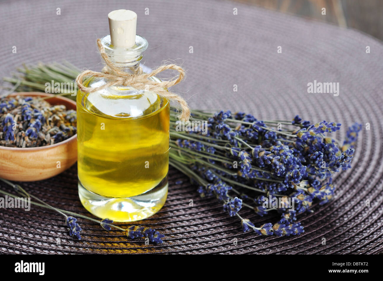 Essenziale di olio di lavanda con fiori freschi in legno Foto Stock