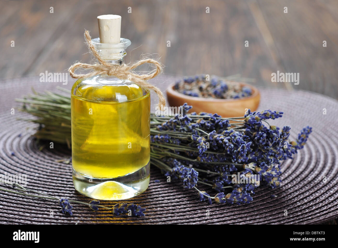 Essenziale di olio di lavanda con fiori freschi su sfondo di legno. messa a fuoco selettiva Foto Stock