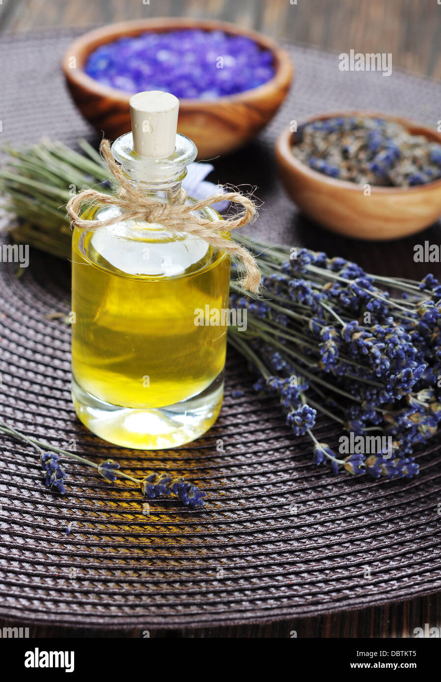 Essenziale di olio di lavanda con fiori freschi su sfondo di legno. messa a fuoco selettiva Foto Stock
