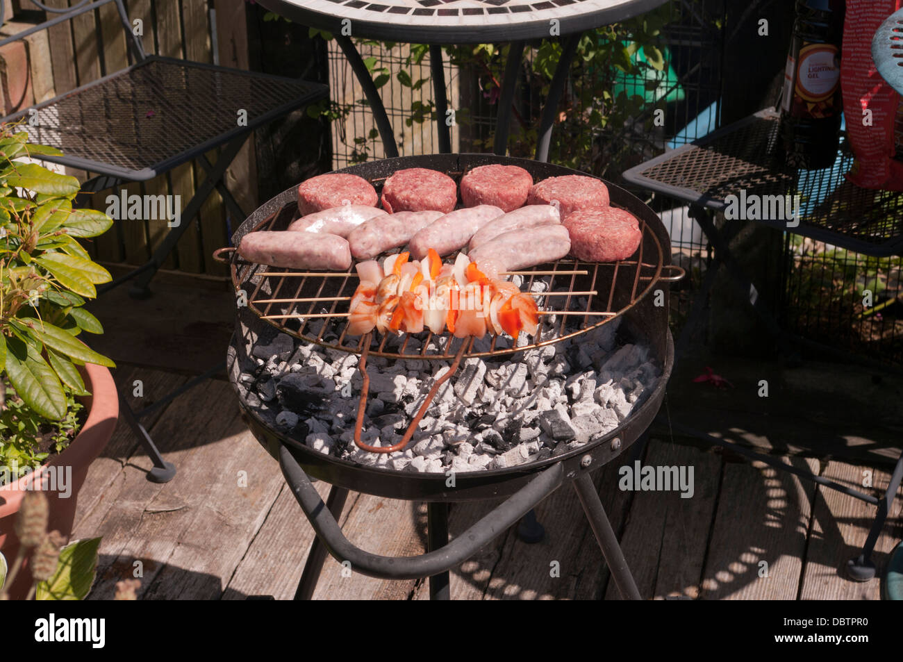 La cottura del cibo sulla barra B Q in una calda giornata estiva Foto Stock