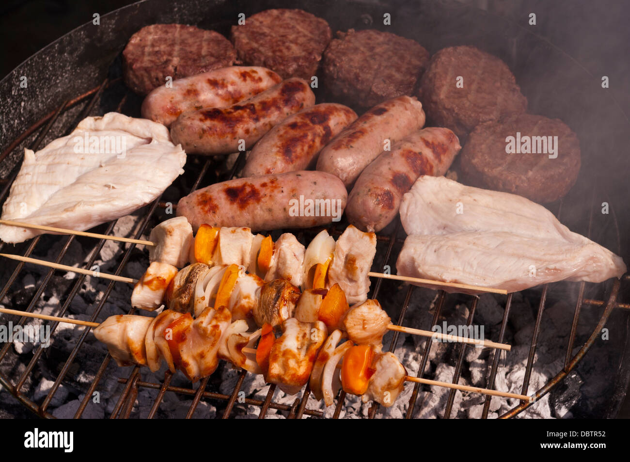Cibo Hamburger Beefburgers salsicce di pollo e spiedini cottura su una barra B Q Foto Stock