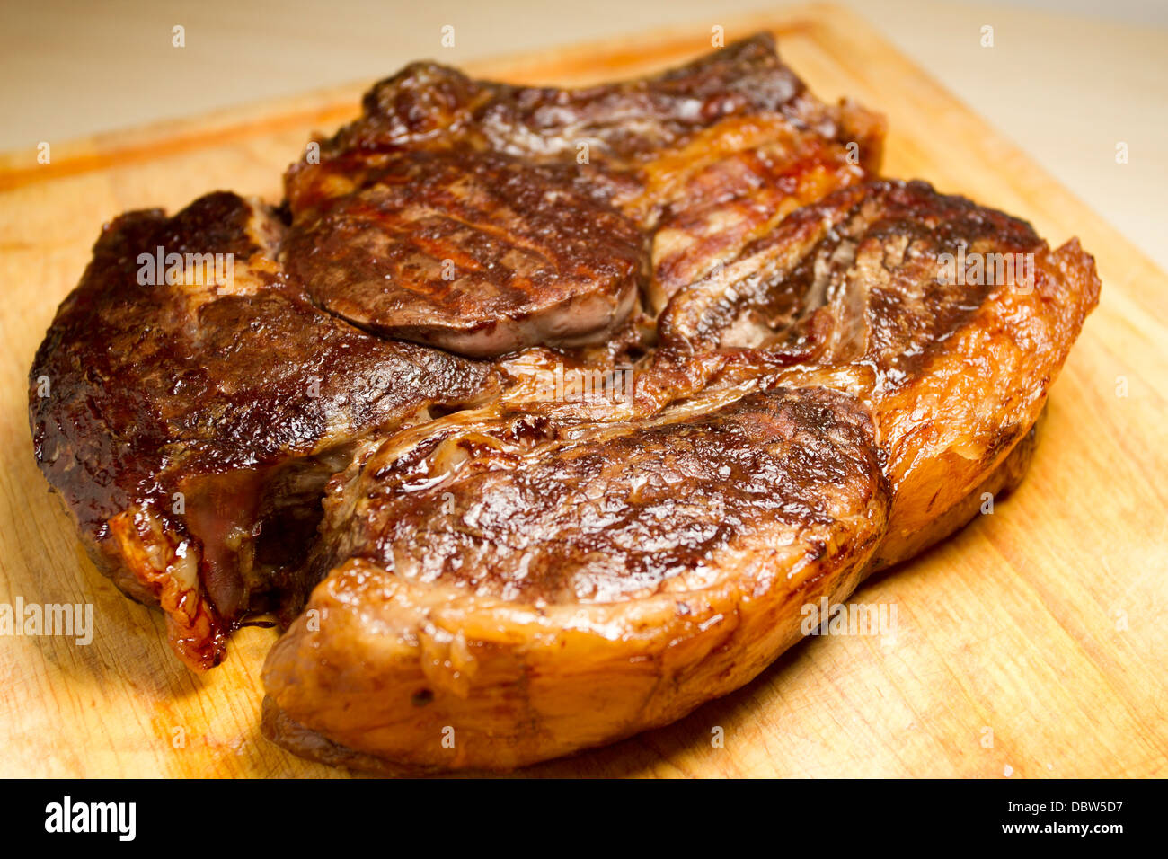 Costola arrosto di carne su un tagliere di legno Foto Stock