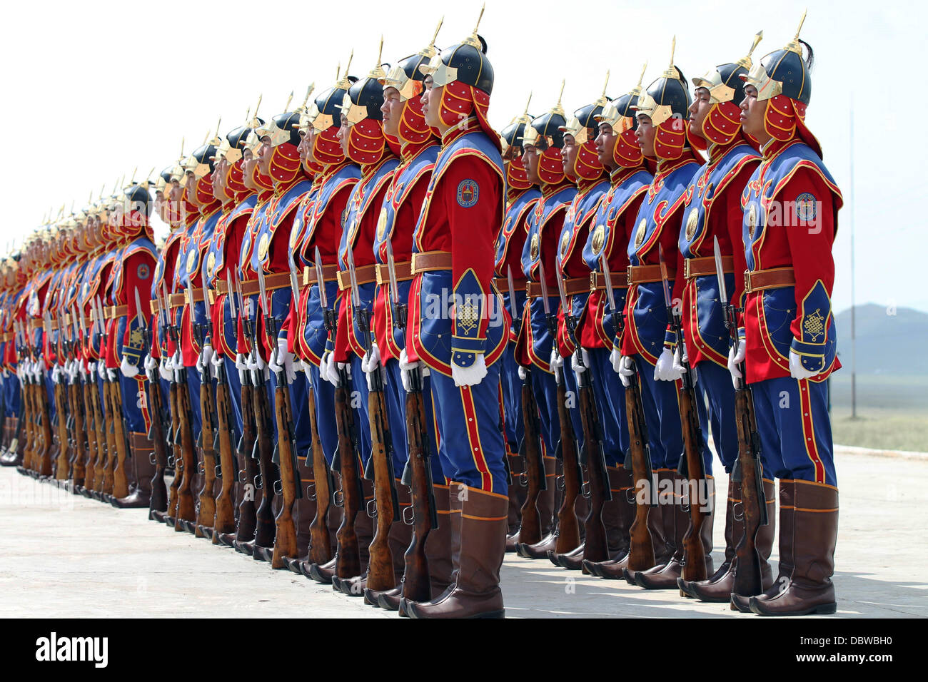 Membri della Mongolia le forze armate guardia onorario in divise tradizionali stand in formazione prima della cerimonia di apertura dell'esercizio Khaan Ricerca Agosto 3, 2013 in cinque colline Area Formazione e Mongolia. Foto Stock