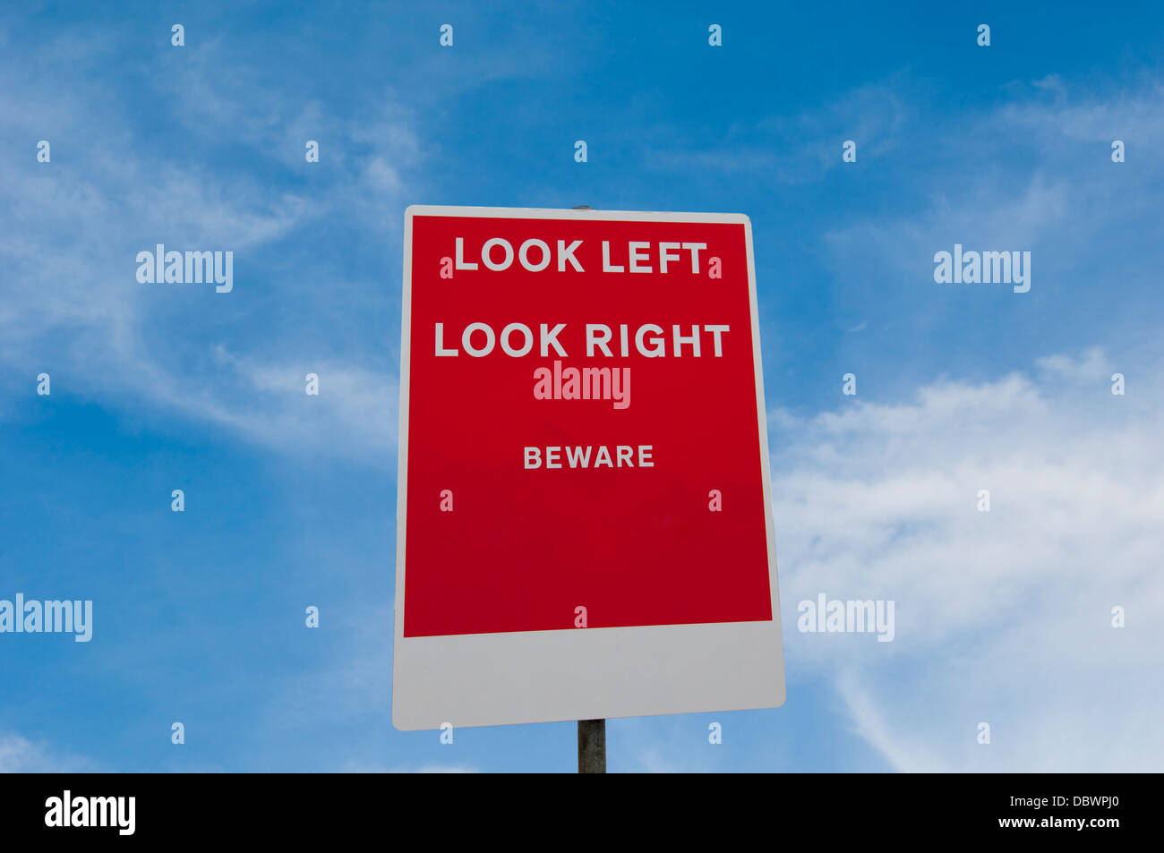 Rosso di guardare a sinistra guardare a destra attenzione segno di avvertimento contro un cielo blu Foto Stock