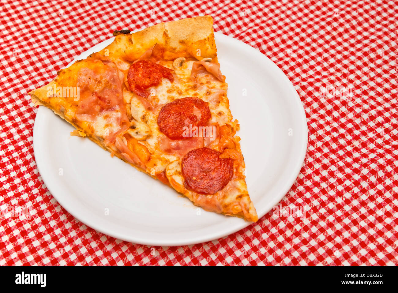 Trancio di Pizza sulla piastra bianca servita sul tavolo da cucina Foto Stock