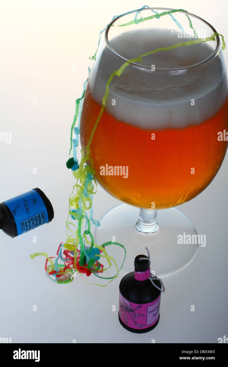 Bicchiere di birra con party popper e streamers Foto Stock