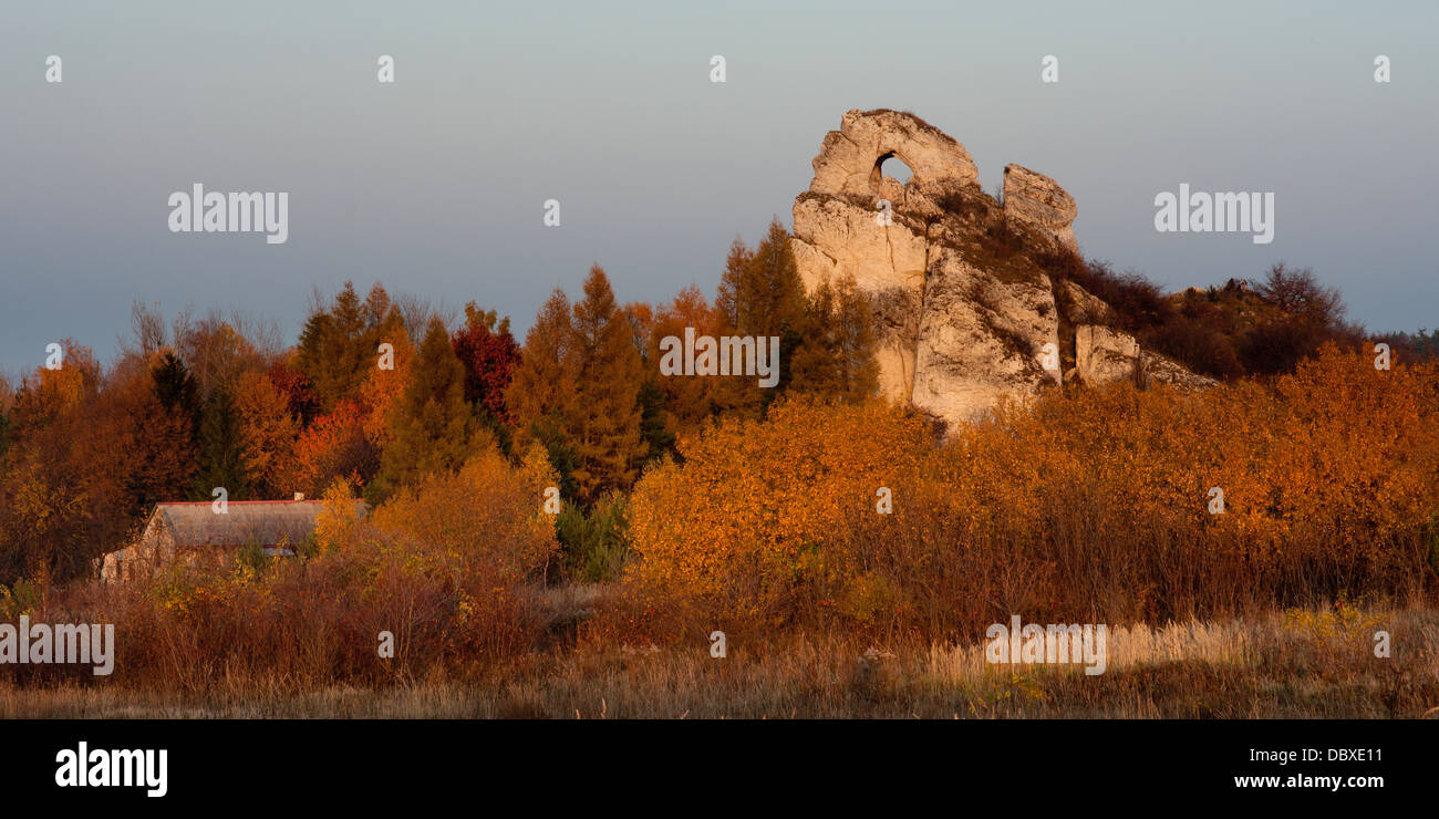 Rock House Bungalow, prato in polacco autunno dorato. I colori del tramonto, del crepuscolo. okiennik wielki, uno dei più grandi massi di polish jura. Polonia centrale. Foto Stock