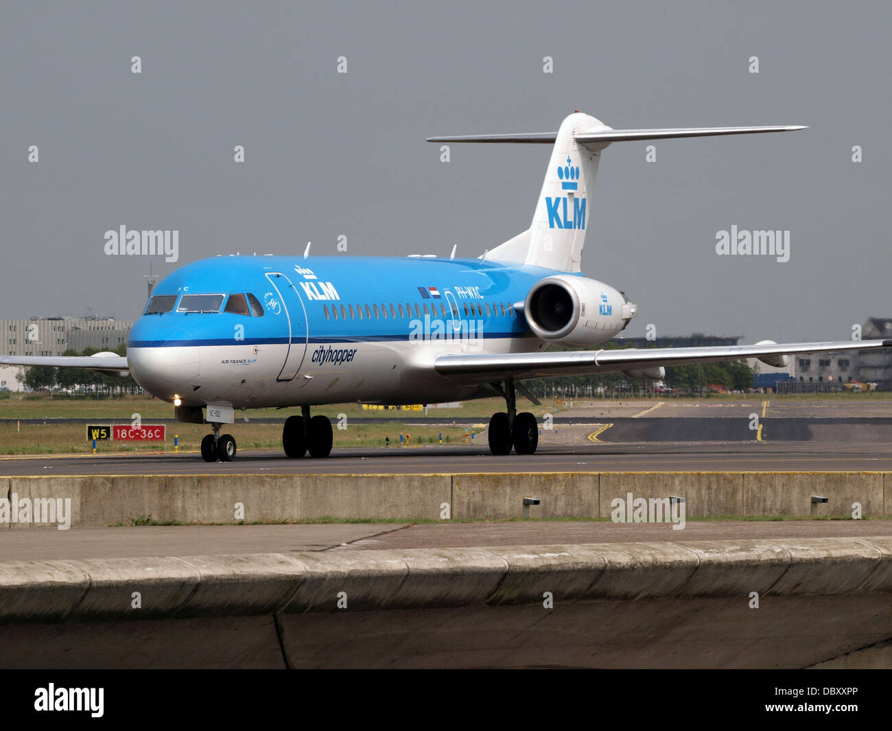 Il KLM Cityhopper Fokker F70, registrato PH-WXC, è un aereo di linea regionale utilizzato per voli nazionali e internazionali a corto raggio. Il 14 luglio 2013, l'aereo è stato fotografato in rullaggio all'aeroporto Schiphol di Amsterdam. Questo velivolo fa parte della flotta regionale di KLM ed è noto per il suo design compatto e per l'efficiente funzionamento su brevi rotte. Foto Stock