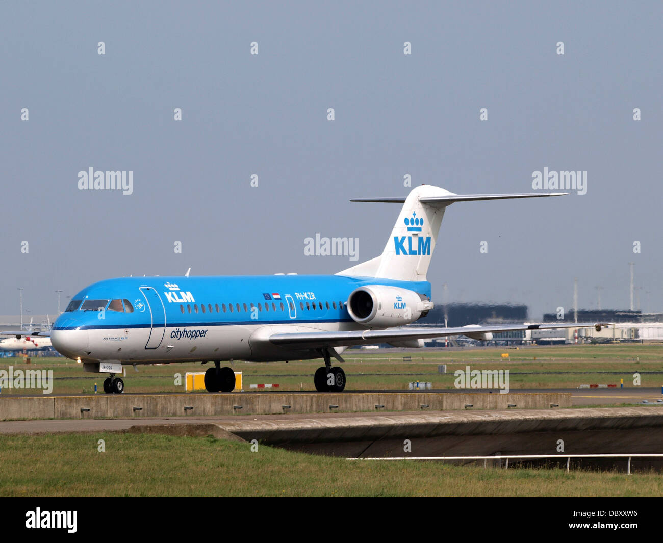 Il PH-KZR è un Fokker F70, un jet regionale gestito da KLM Cityhopper. Visto che arriva qui all'aeroporto di Schiphol, viene utilizzato per rotte di breve e medio raggio in Europa, offrendo un efficiente servizio passeggeri. Foto Stock