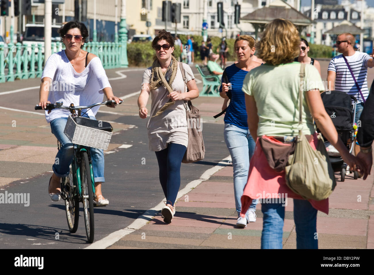 Ciclista e pedone passeggiate sul lungomare di Brighton East Sussex England Regno Unito Foto Stock