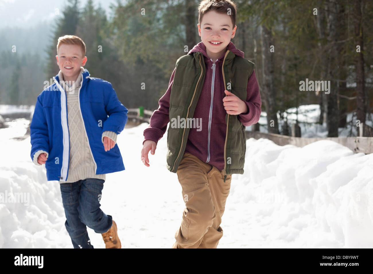 Ritratto di felice ragazzi in esecuzione in corsia nevoso Foto Stock