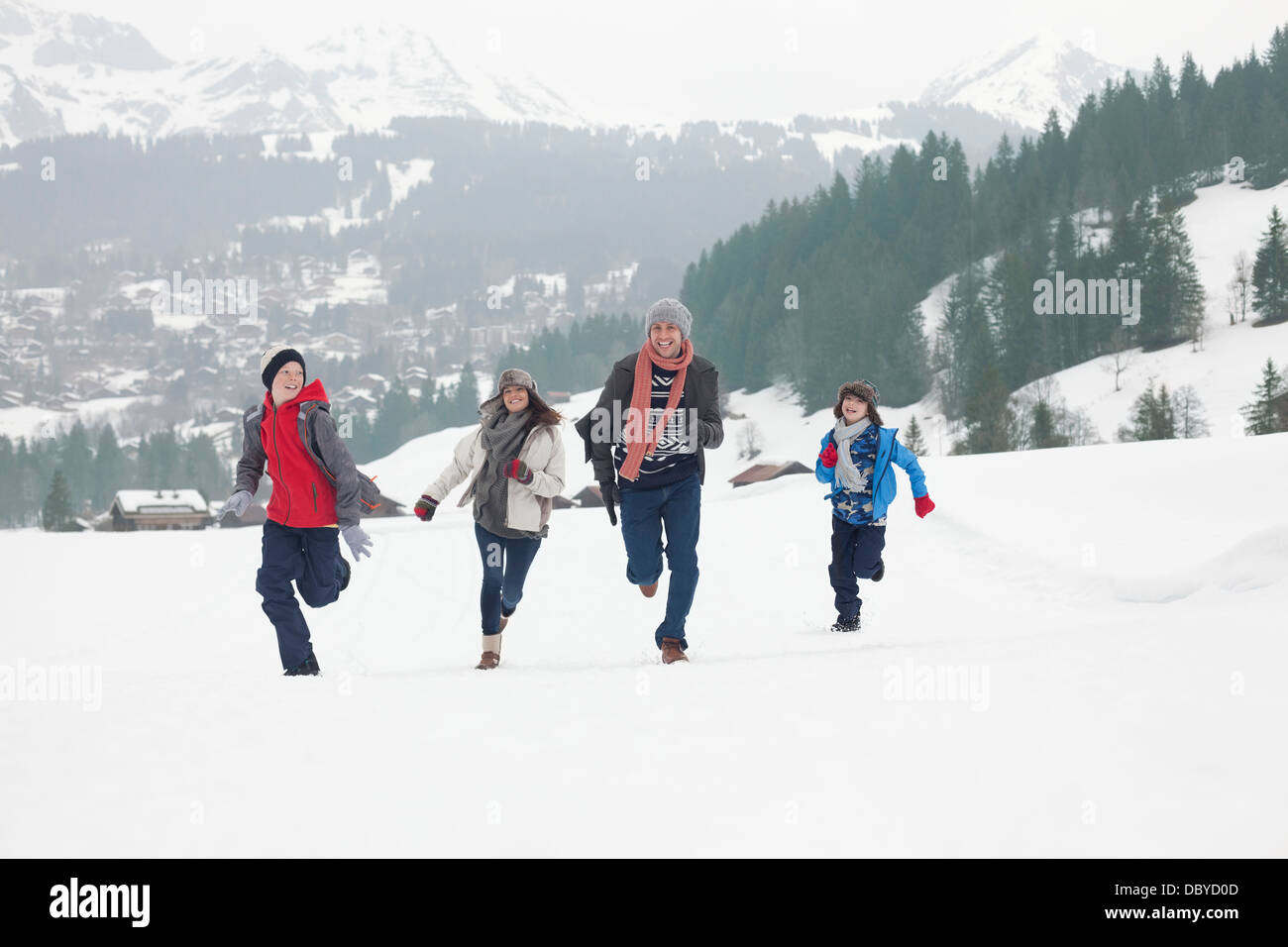 Famiglia in esecuzione in campo nevoso Foto Stock
