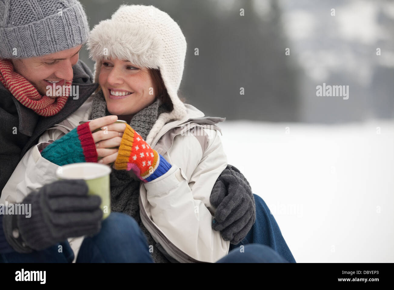 Coppia felice di bere il caffè nella neve Foto Stock