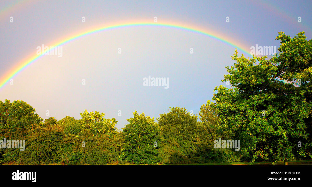 L'arcobaleno in un cielo chiaro oltre la campagna inglese Foto Stock