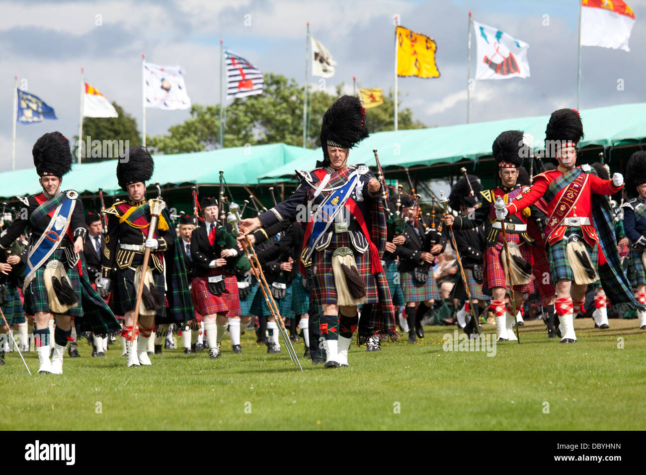 Aboyne, Scozia - Agosto 3rd, 2013: ammassato bande di cornamuse entrando nel campo presso l'Highland Games. Foto Stock