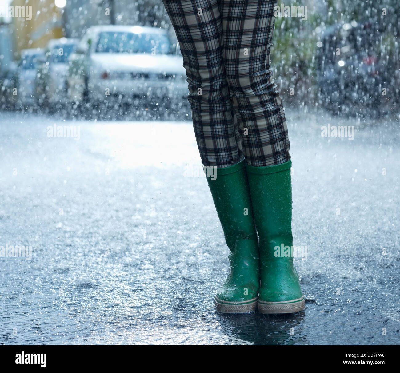 Pioggia caduta intorno a donna in wellingtons Foto Stock