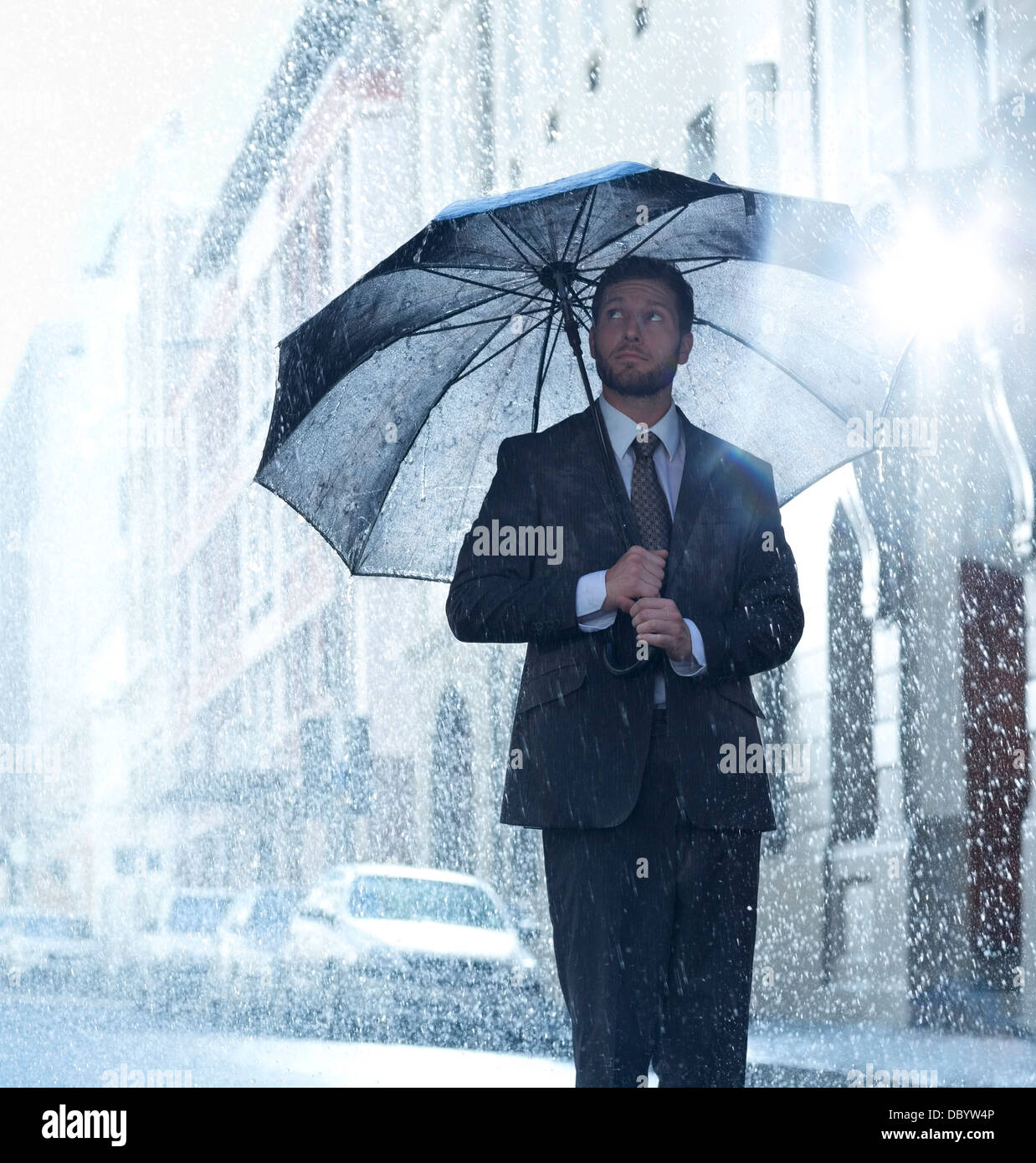 Imprenditore sotto ombrellone in rainy street Foto Stock