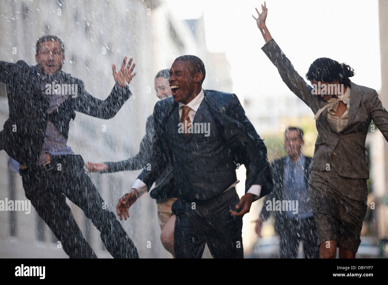 Entusiasta la gente di affari in esecuzione in rainy street Foto Stock