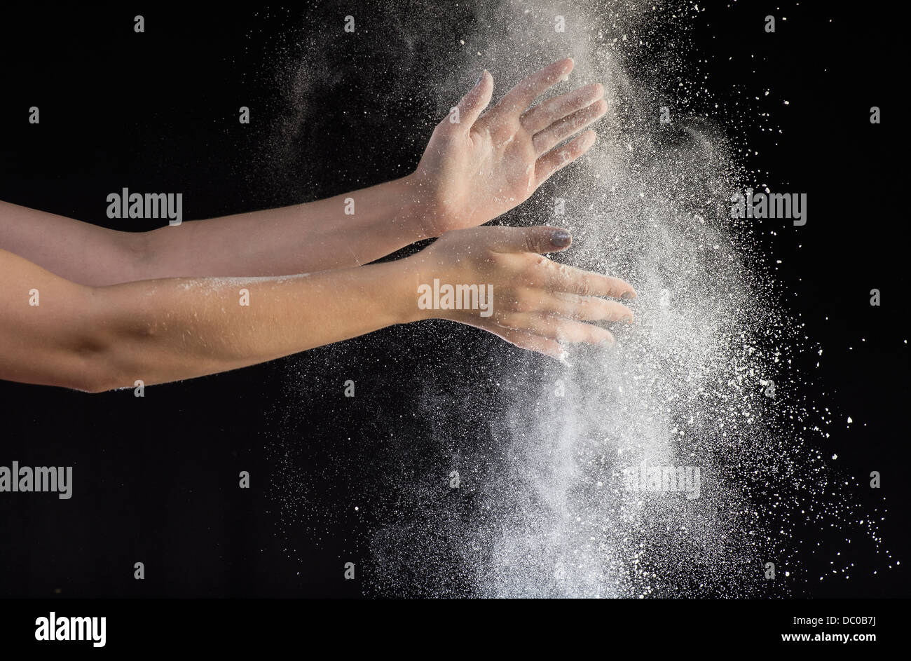 Battendo le mani con polvere bianca Foto Stock