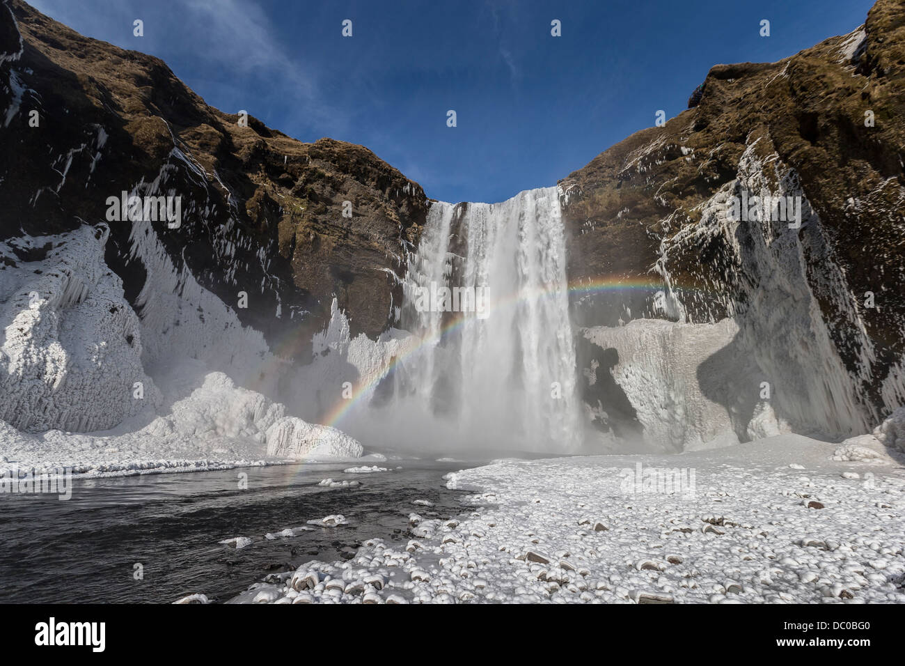 Congelati cascata Skogafoss con arcobaleno, Islanda. Foto Stock