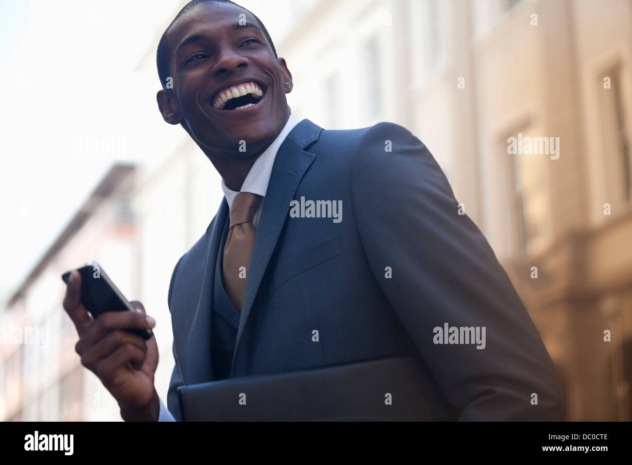 Imprenditore entusiasta per la messaggistica di testo con un telefono cellulare Foto Stock