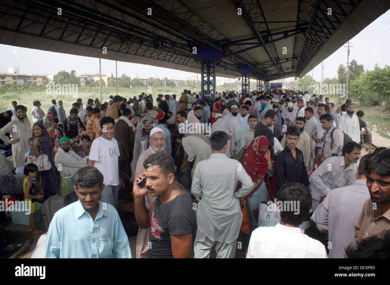 Un grande numero di passeggeri seduti turbato e in attesa per il treno come Lo Shalimar Express è in ritardo dalla sua pianificazione, sulla piattaforma alla stazione di Cantt a Karachi in Pakistan . Foto Stock