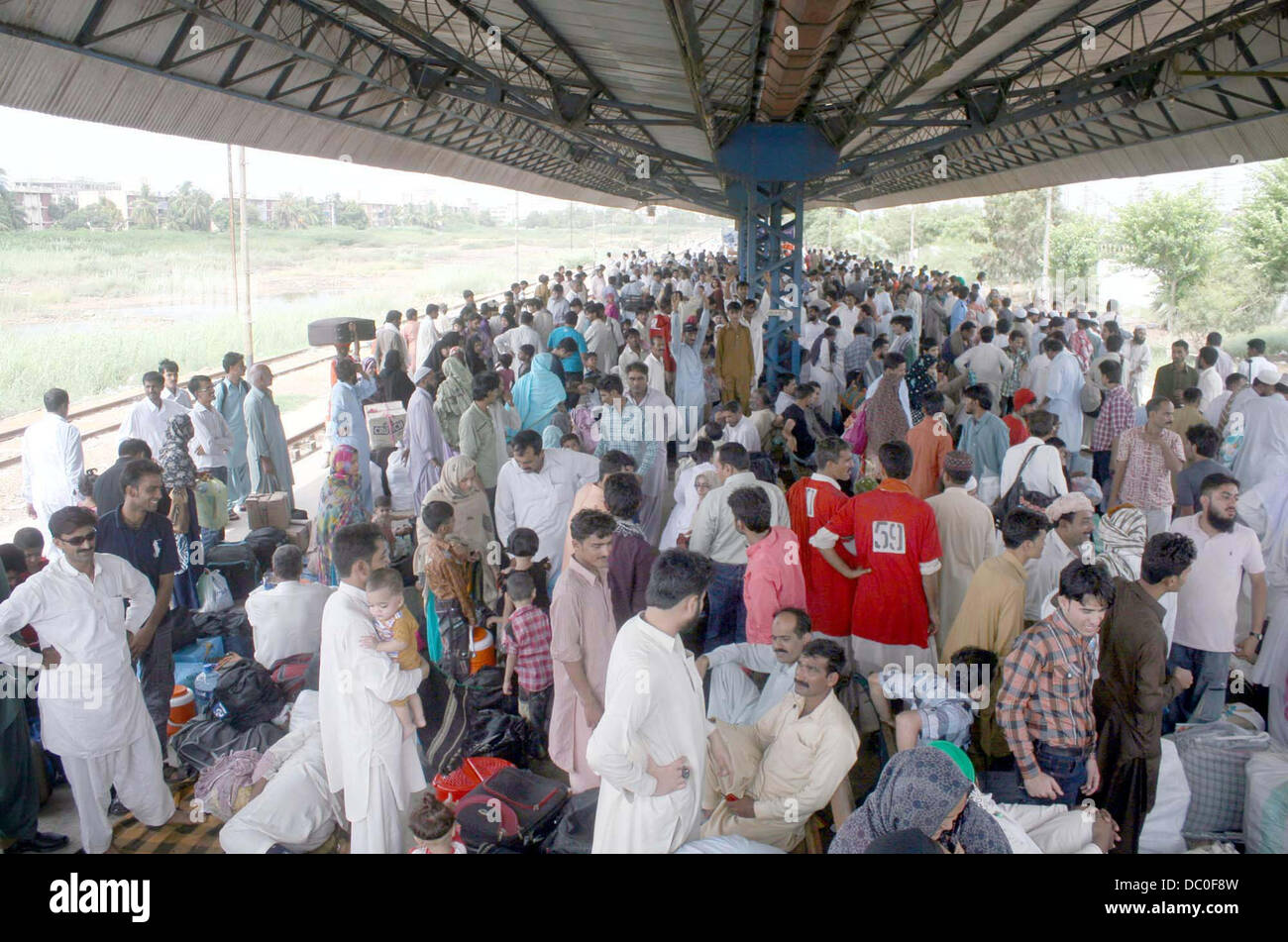 Un grande numero di passeggeri seduti turbato e in attesa per il treno come Lo Shalimar Express è in ritardo dalla sua pianificazione, sulla piattaforma alla stazione di Cantt a Karachi in Pakistan . Foto Stock