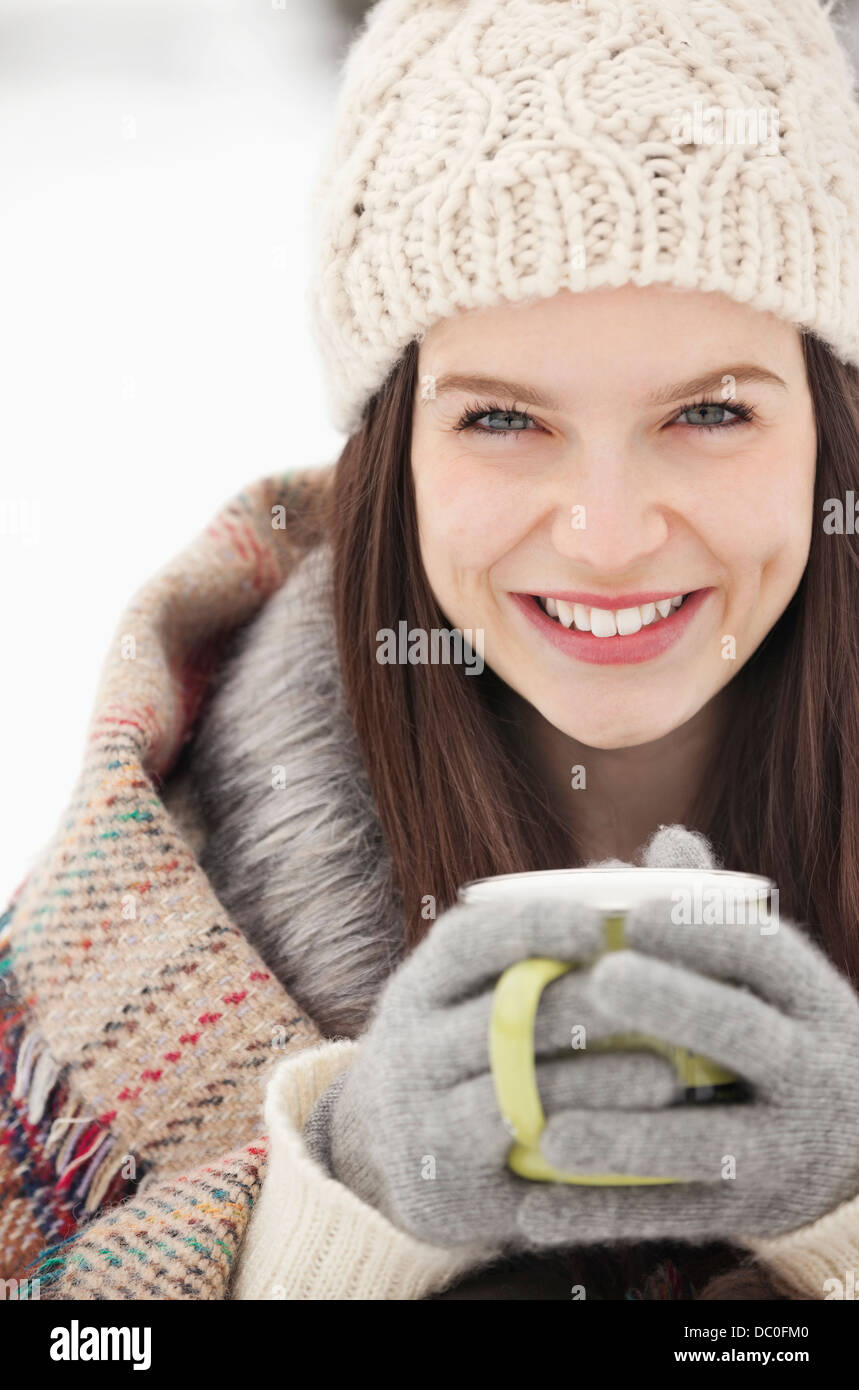 Close up ritratto di donna in maglia guanti e cappello di bere il caffè Foto Stock