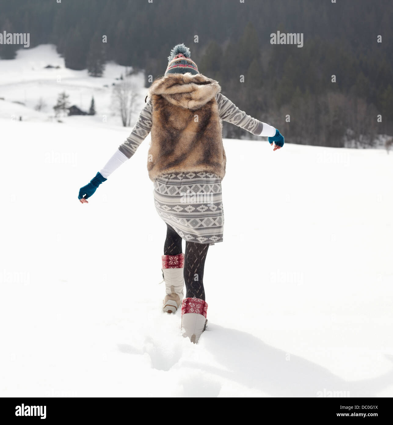 Donna che cammina nel campo nevoso Foto Stock