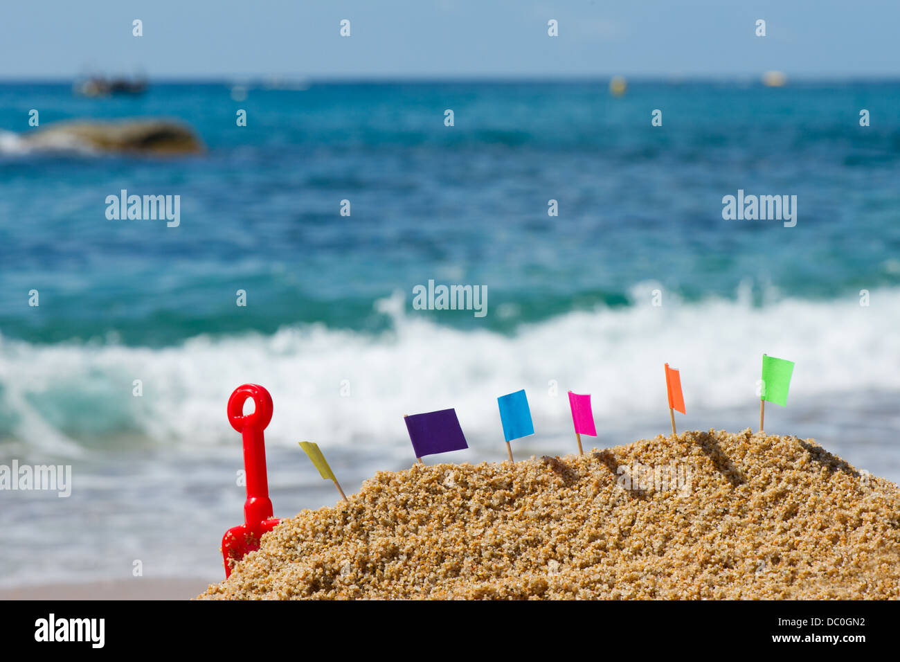 Castello di sabbia con bandiere colorate in spiaggia Foto Stock