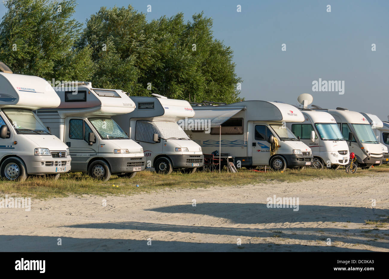 Una fila di autocaravan rivolta verso il sole e parcheggiata per la notte sull'Aire de camping, Le Crotoy, dipartimento della Somme, in Piccardia, nella Francia settentrionale, l'Europa. Foto Stock