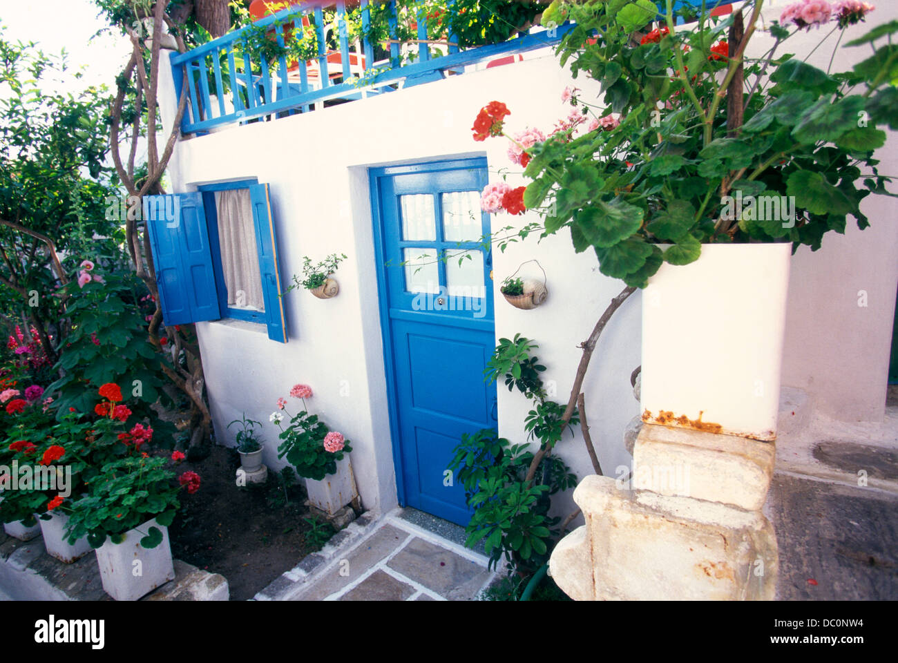 MYKONOS Grecia Casa bianca con rivestimento blu e gerani Foto Stock