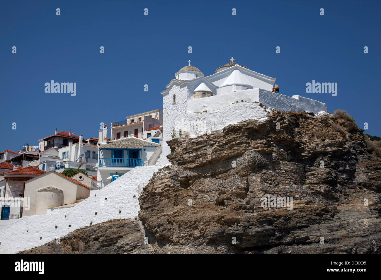 Case e una chiesa costruita sulla roccia nella città di Skopelos Foto Stock