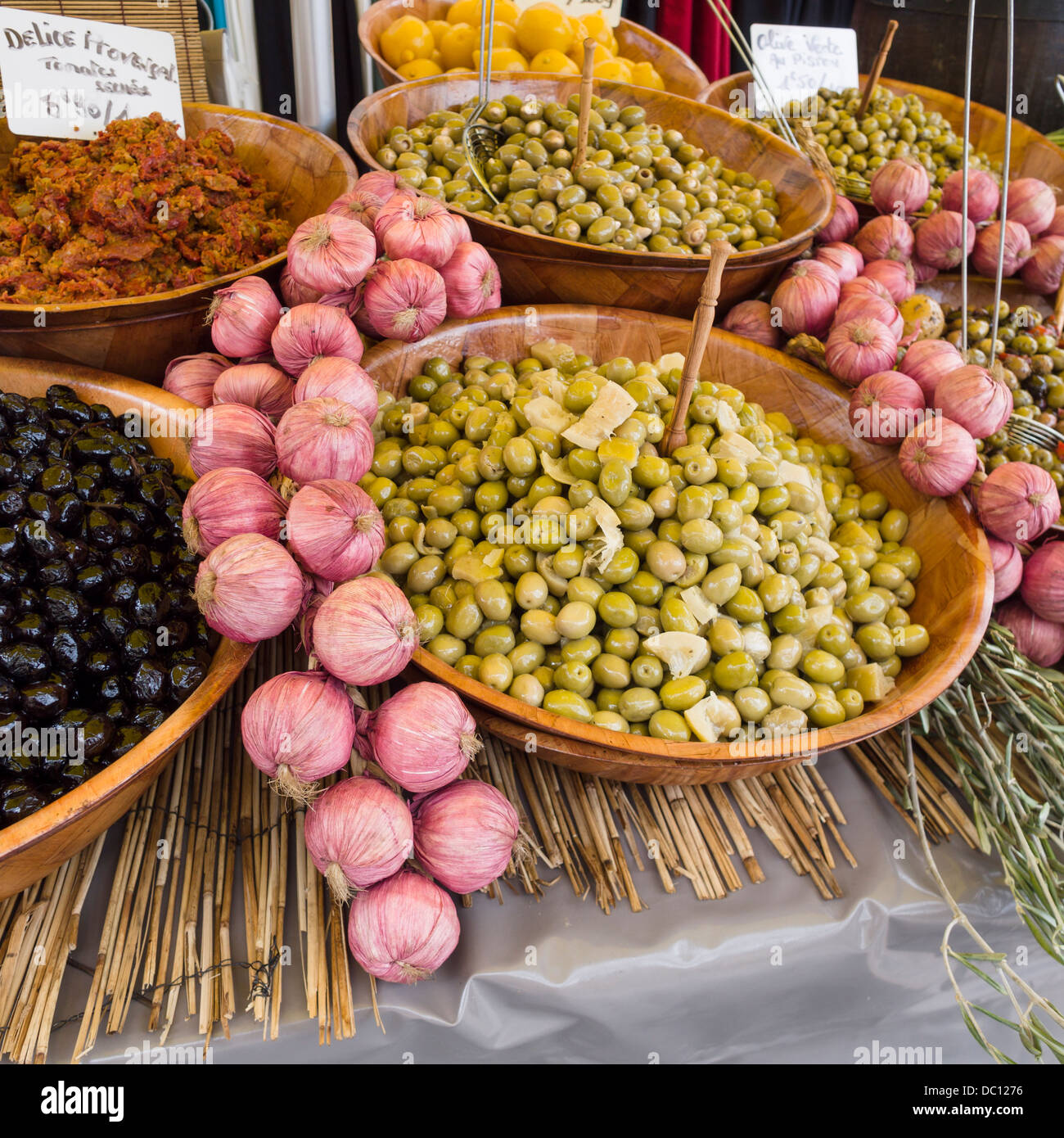 Le olive e l'Aglio nel mercato. Un display artistico di aglio e le olive in un piccolo mercato locale. Foto Stock