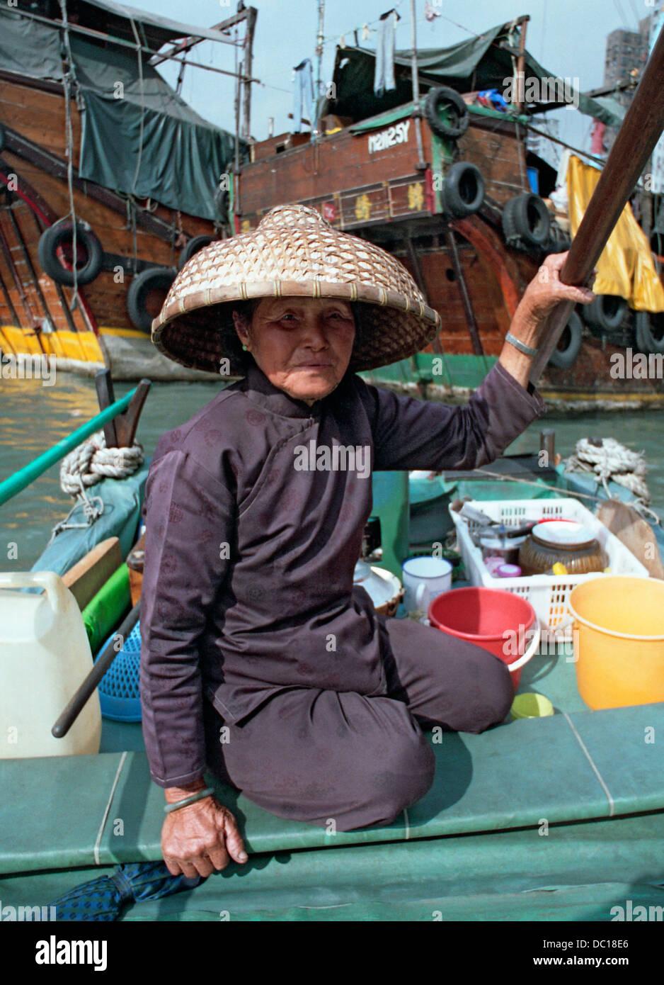 Un junk donna che indossa un tradizionale cappello di bambù nel porto di Hong Kong. Foto Stock
