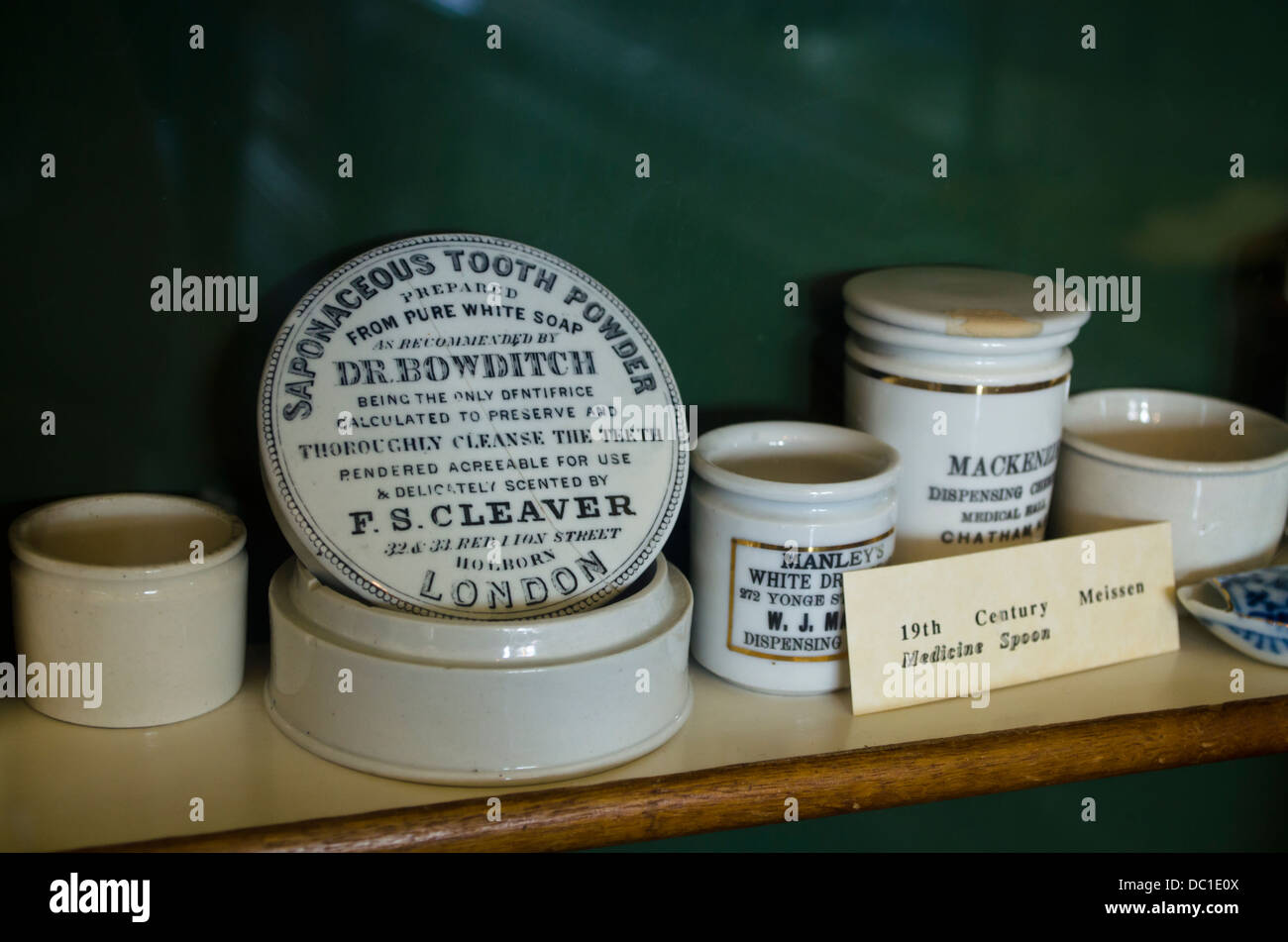 Scaffale con vintage contenitori in ceramica del dente in polvere ed altri articoli medicinali dal tardo ottocento nel Niagara speziale. Foto Stock