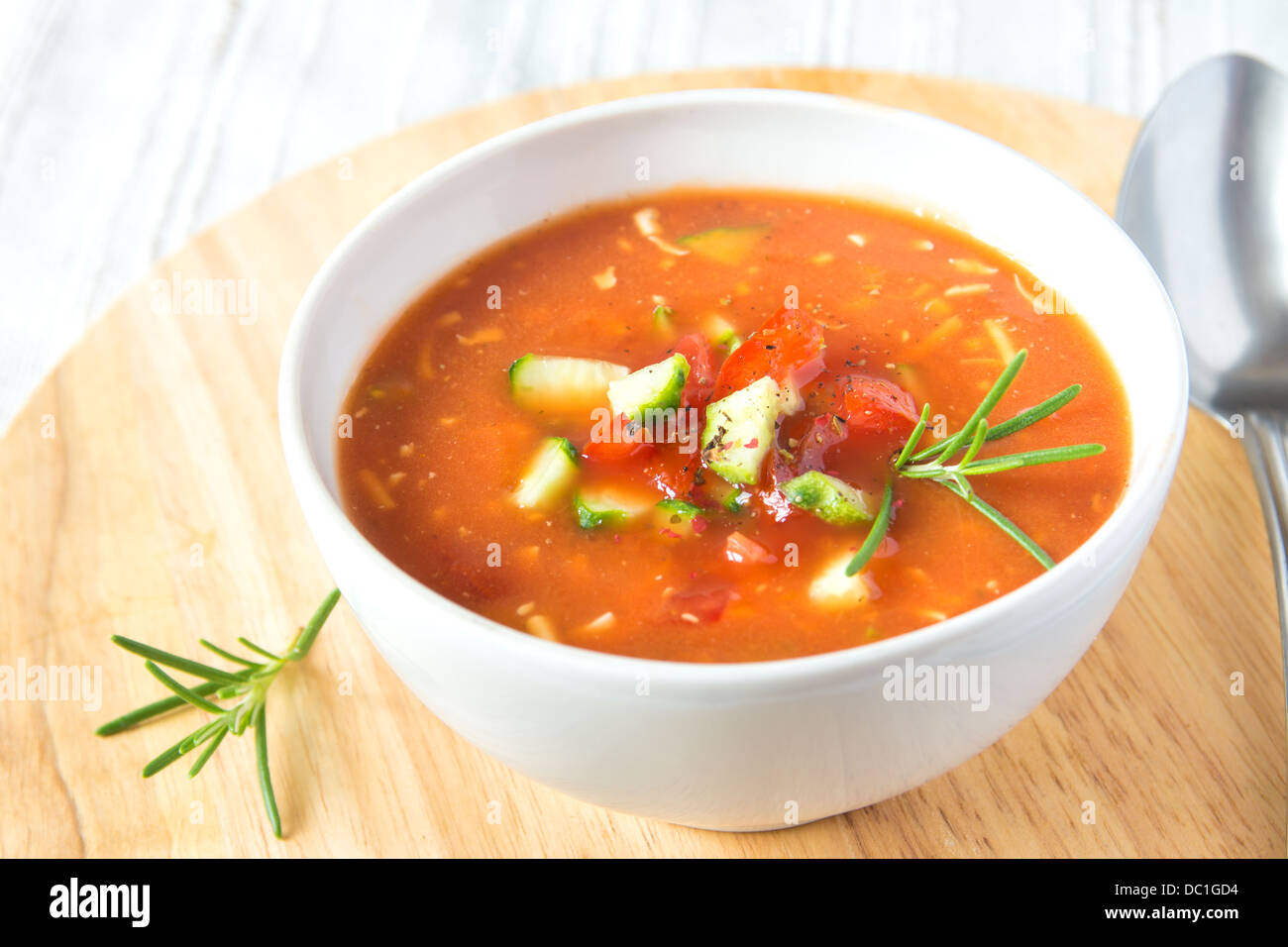Delizioso dolce freddo gustosa minestra di pomodoro gazpacho in bianco ciotola con cucchiaio su tavola di legno, primo piano, orizzontale Foto Stock