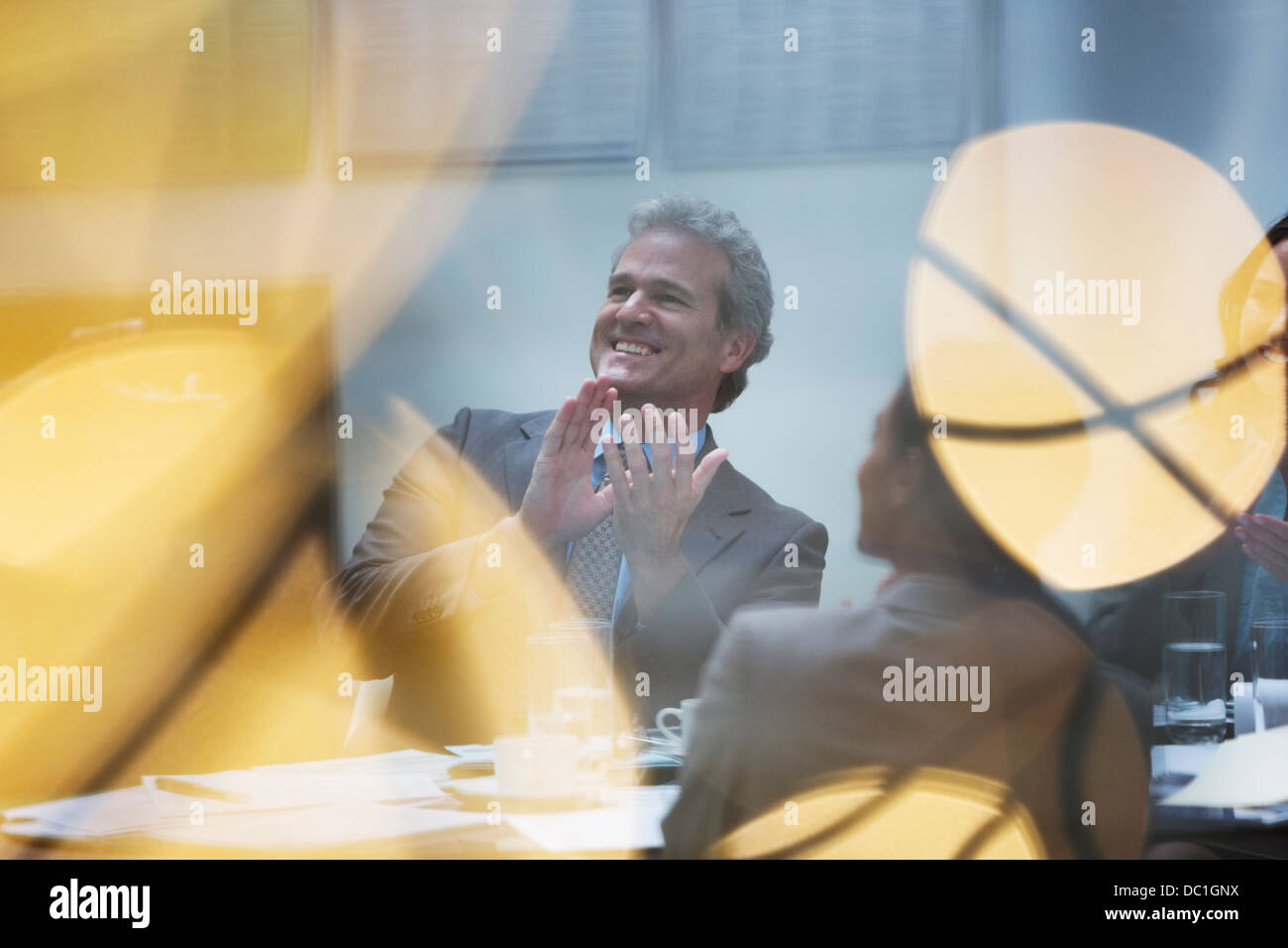 Imprenditore sorridente battendo le mani in riunione Foto Stock