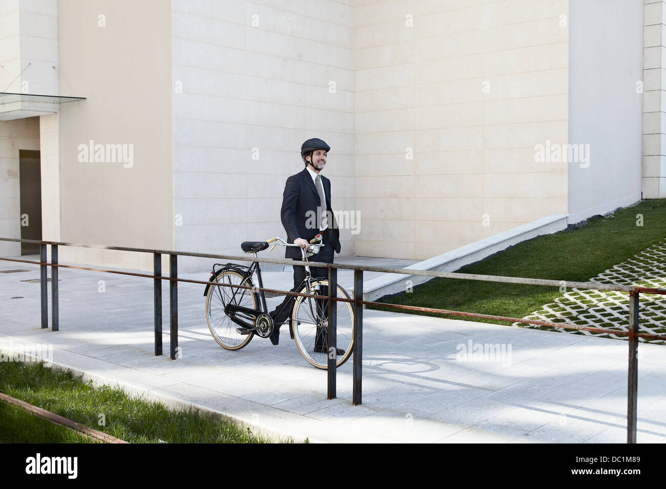 Adulto medio imprenditore camminando con la bicicletta Foto Stock