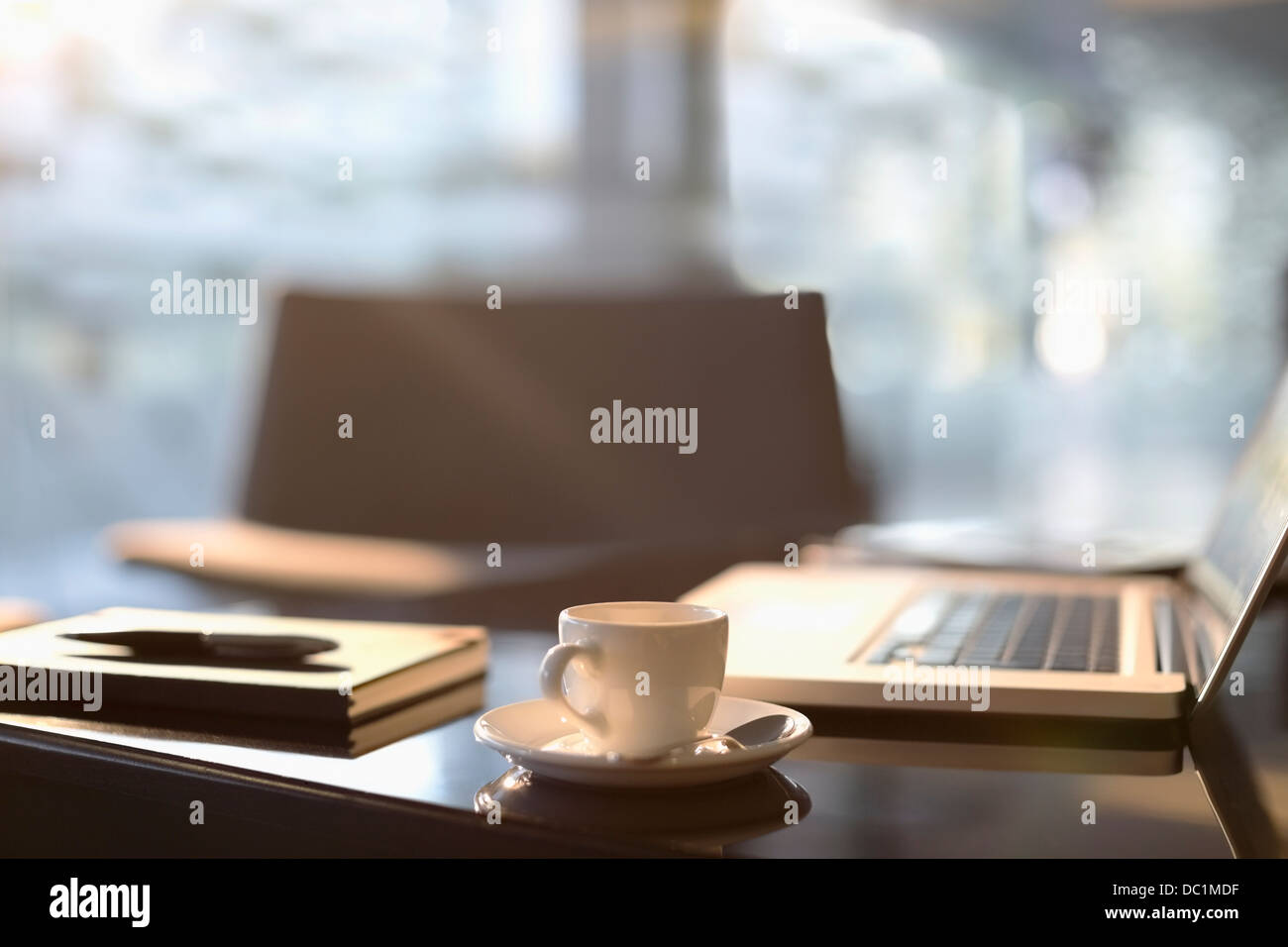 Tazza da caffè, laptop, notebook e penna in ufficio Foto Stock