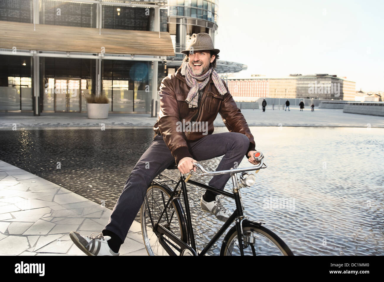 Metà uomo adulto godendo in bicicletta in città Foto Stock