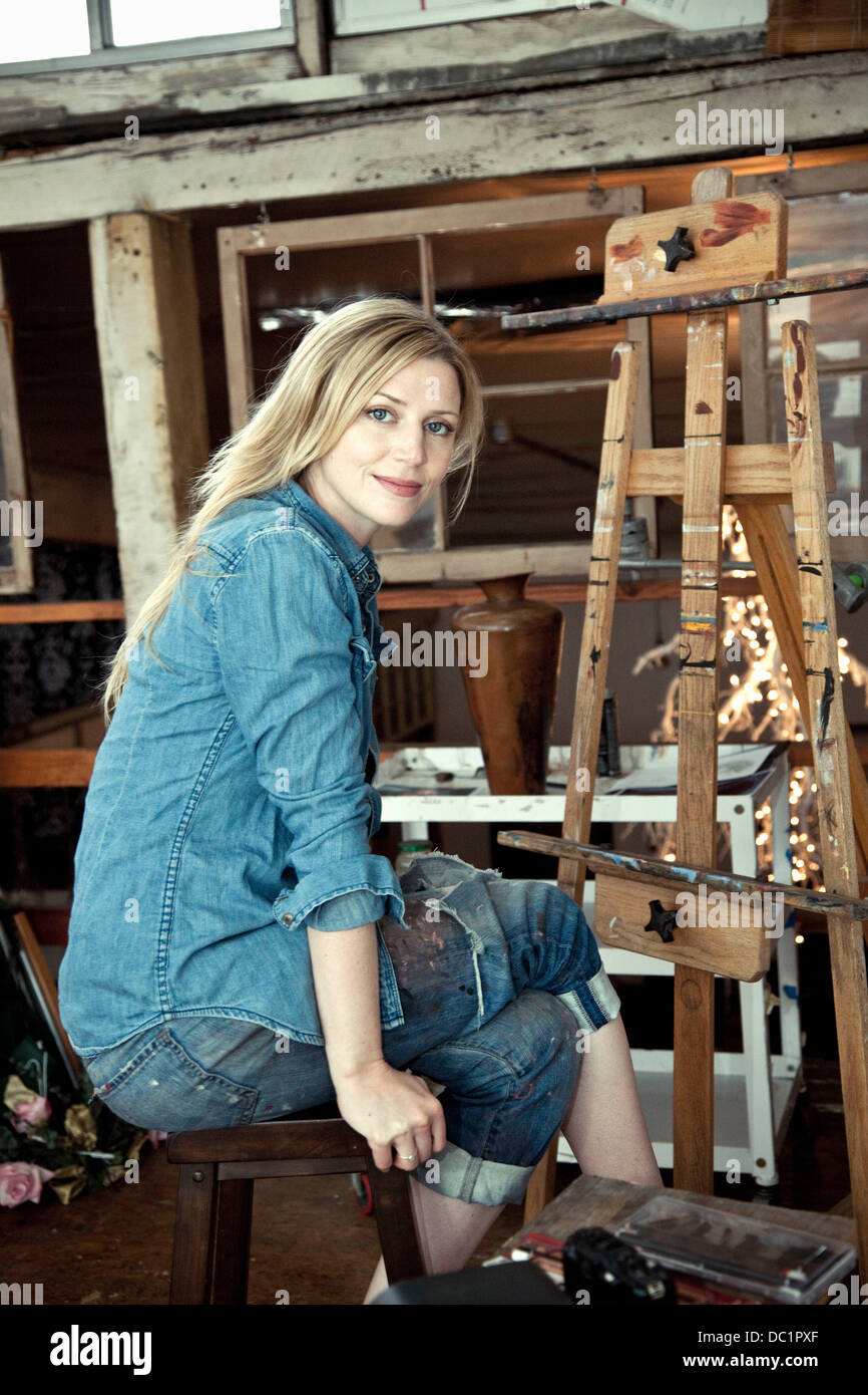 Metà donna adulta seduta in artist's studio, ritratto Foto Stock