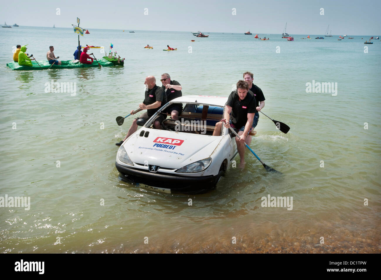 Quattro uomini canottaggio un auto a terra dopo la concorrenza in Brighton il Paddle Round Il molo concorso per wacky craft. Foto Stock