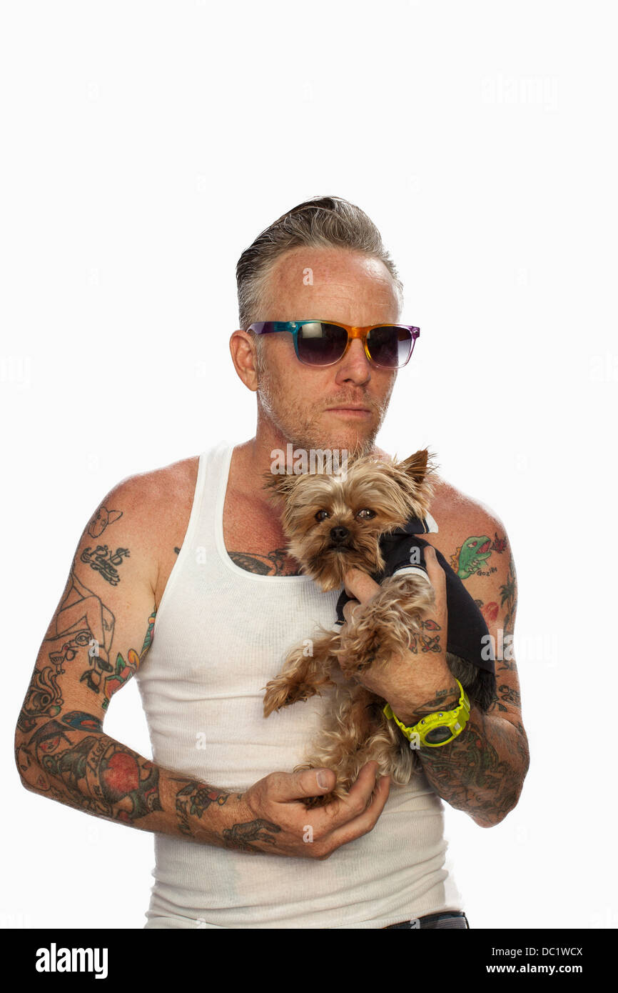 Uomo maturo holding tazzina Yorkshire terrier contro uno sfondo bianco Foto Stock