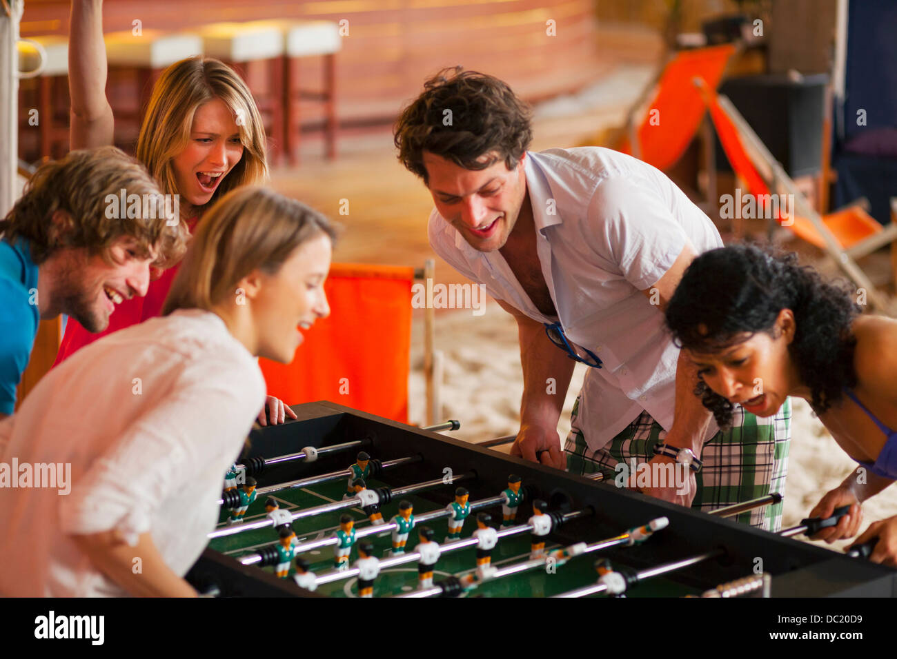 Gli amici di divertirsi giocando a calcio balilla Foto Stock