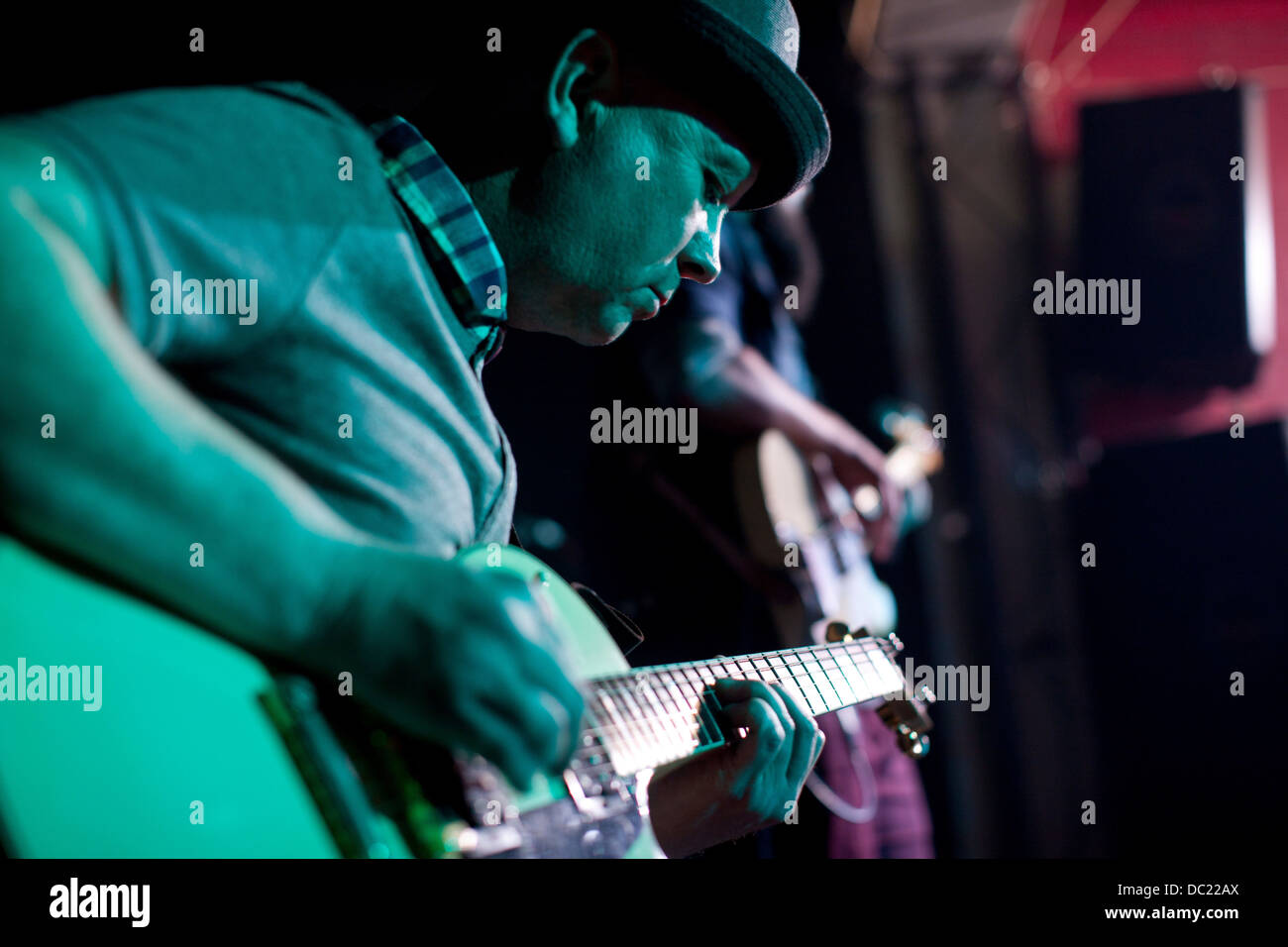 Uomo a suonare la chitarra sul palco in discoteca Foto Stock
