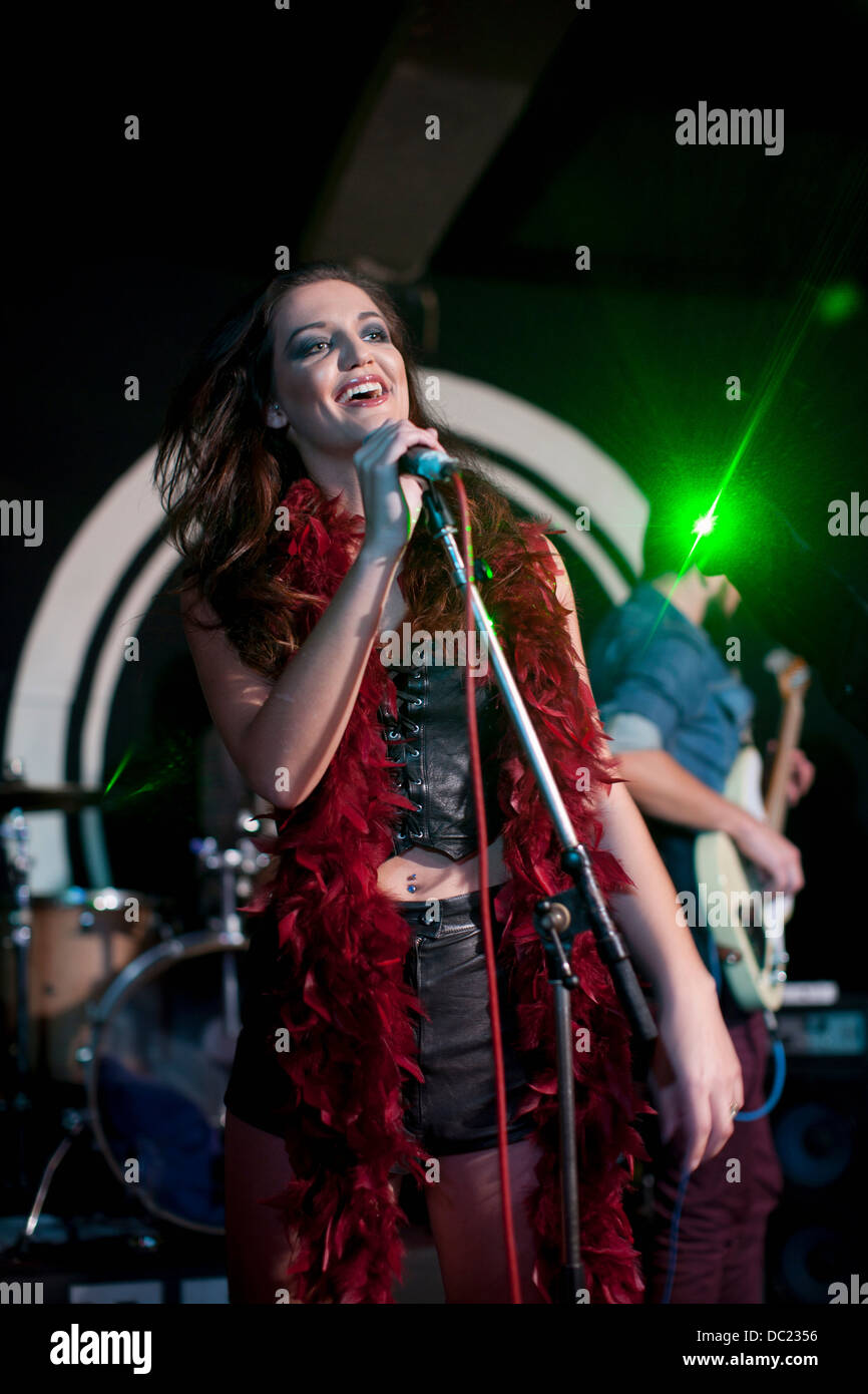 Giovane femmina canto sul palco in club Foto Stock